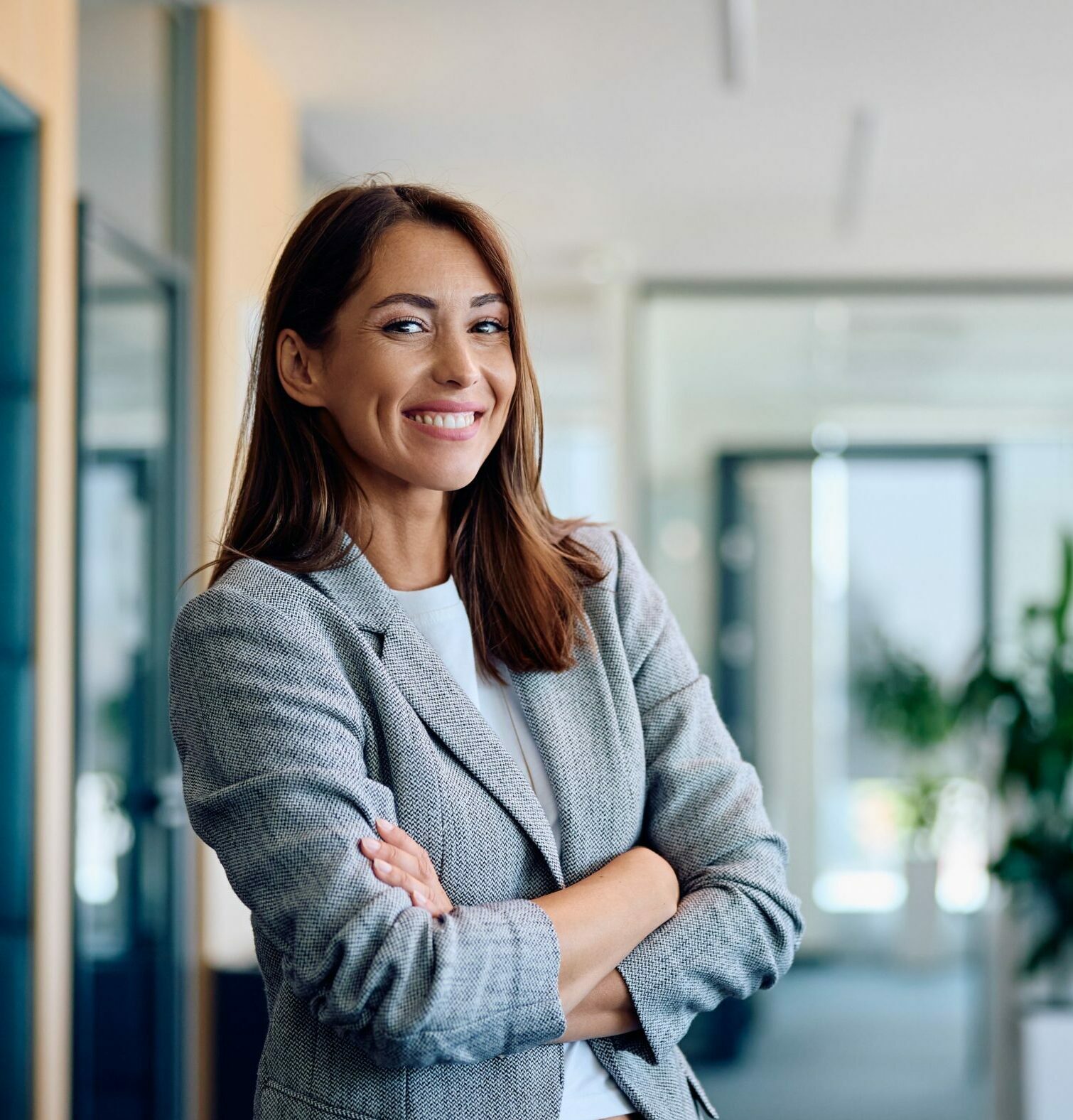 Young,Happy,Businesswoman,With,Arms,Crossed,Standing,Int,He,Office