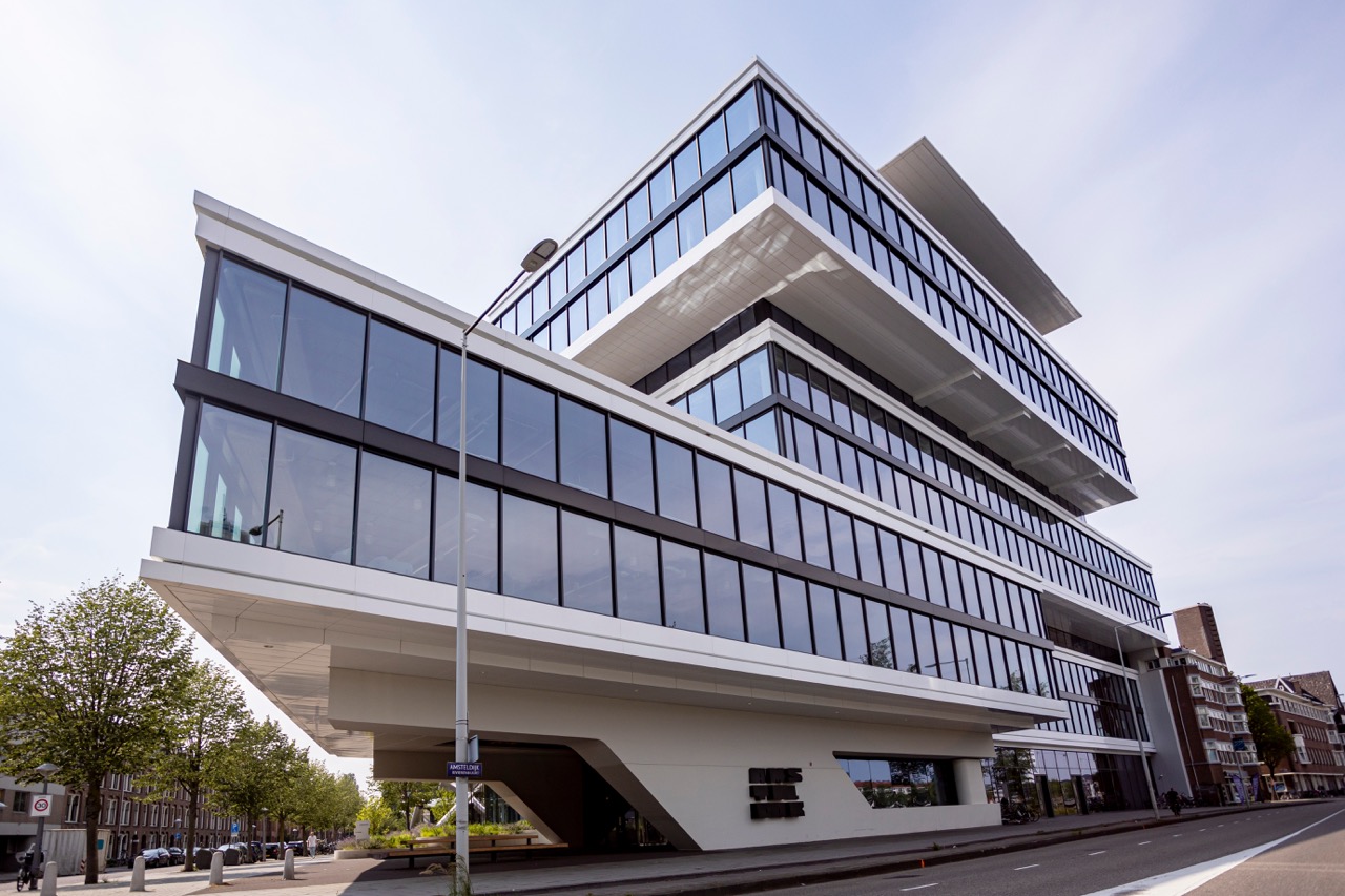 Amsterdam, The Netherlands -  June   26, 2021: Contemporary modern Dutch corporate office building with architectural detail in sharp edged leading lines of glass and concrete exterior facade